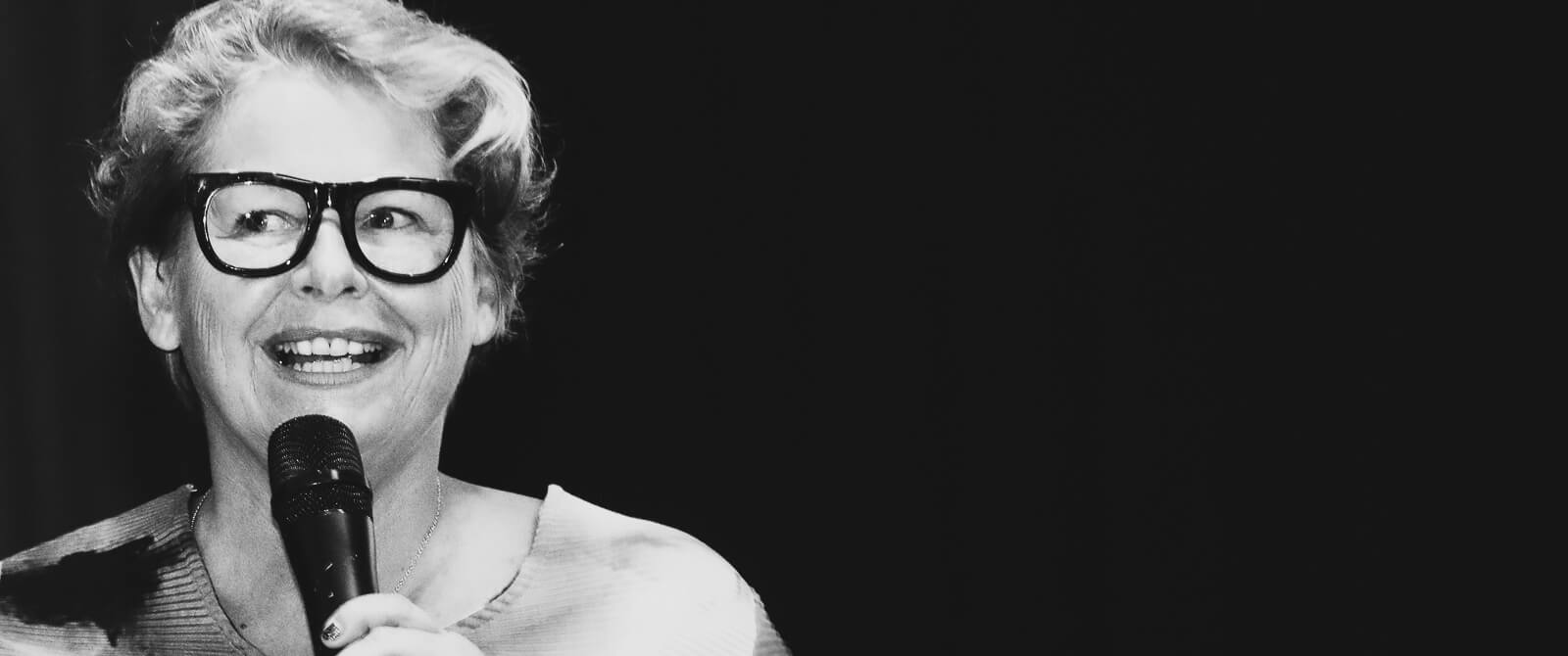 Claire Lassonnery, French contemporary abstract artist, black and white portrait, speaking at microphone, large glasses, Kuala Lumpur